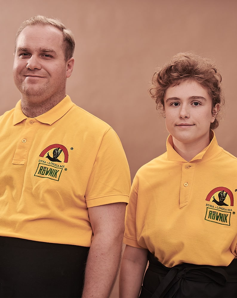 Zdjęcie Piotra i Marty pozujących w żółtych koszulkach Café Równik. Obydwoje uśmiechają się.