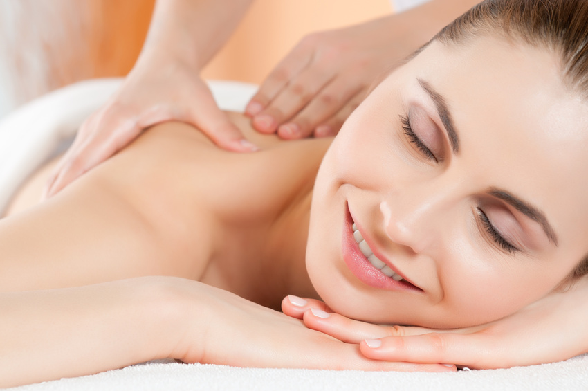 uśmiechnięta kobieta w trakcie masażu pleców