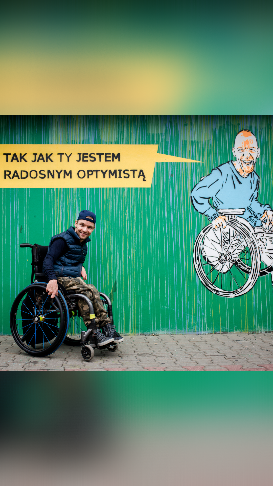 Podopieczny Fundacji pod swoim wizerunkiem na muralu Helpuj.pl