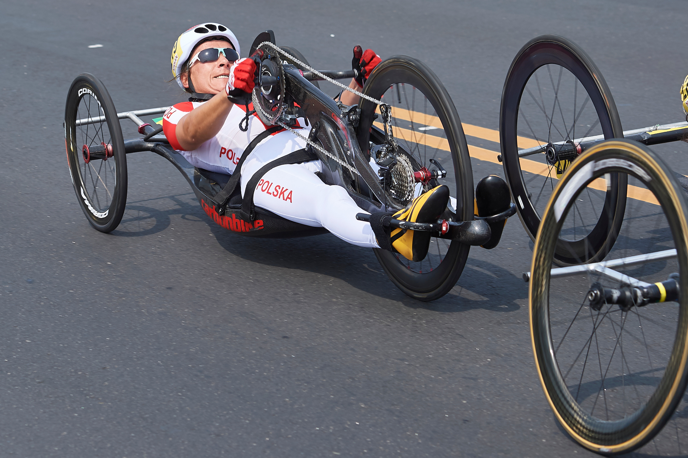 Na zdjęciu znajduje się Renata Kałuża na handbike'u w trakcie wyścigu.