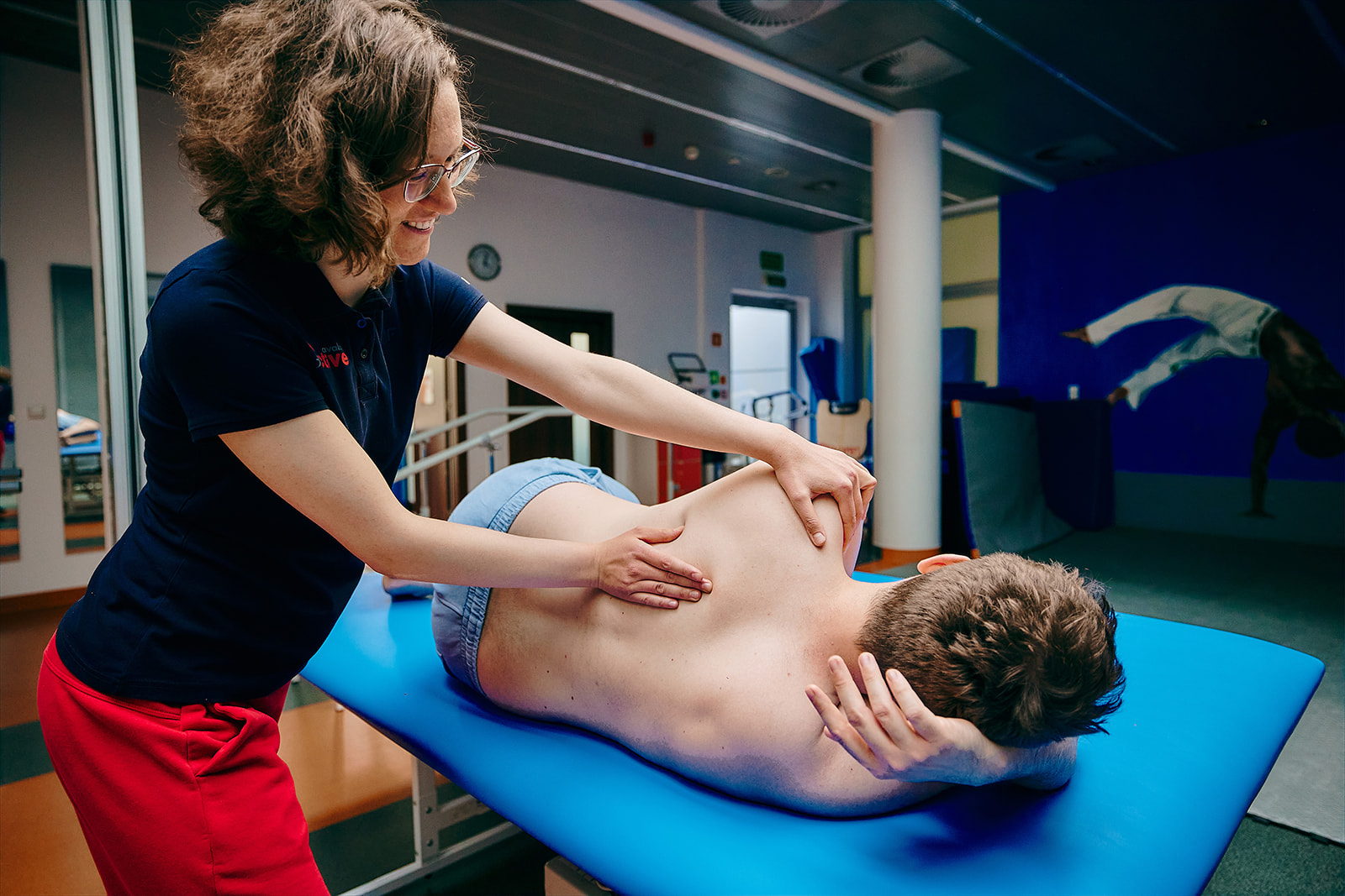 Na zdjęciu fizjoterapeutka uciskająca ramię pacjenta w celu proprioceptywnego torowania mięśniowego.