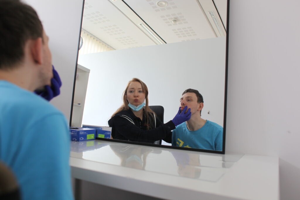 Na zdjęciu logopedka z pacjentem podczas zajęć z terapii manualnej w logopedii.