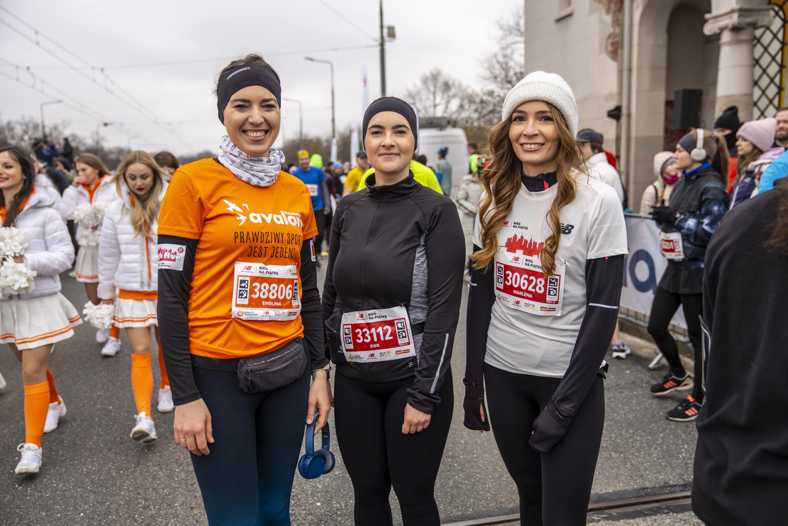 Na zdjęciu trzy uśmiechnięte uczestniczki maratonu warszawskiego - stoją i pozują do zdjęcia. Jedna z nich w koszulce Fundacji Avalon.