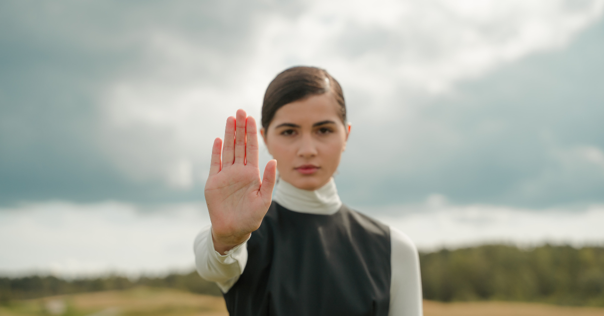 Kobieta wyciąga przed sobą rękę w geście symbolizującym 